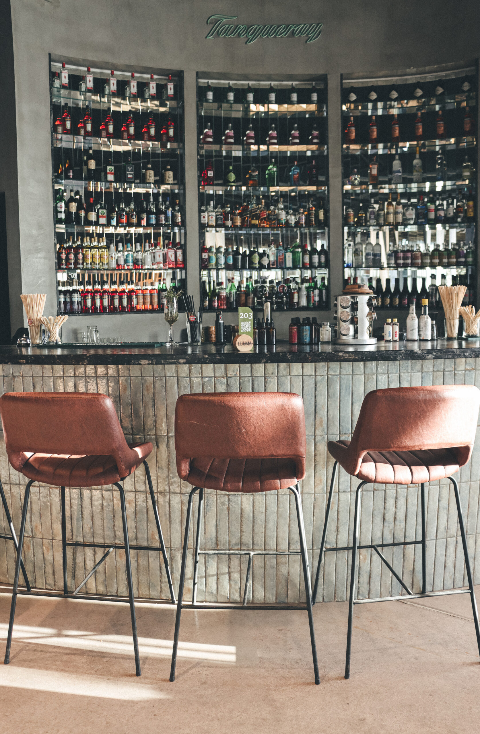 Banquetas altas en barra de cocina con mesada de granito negro Boreal leather
