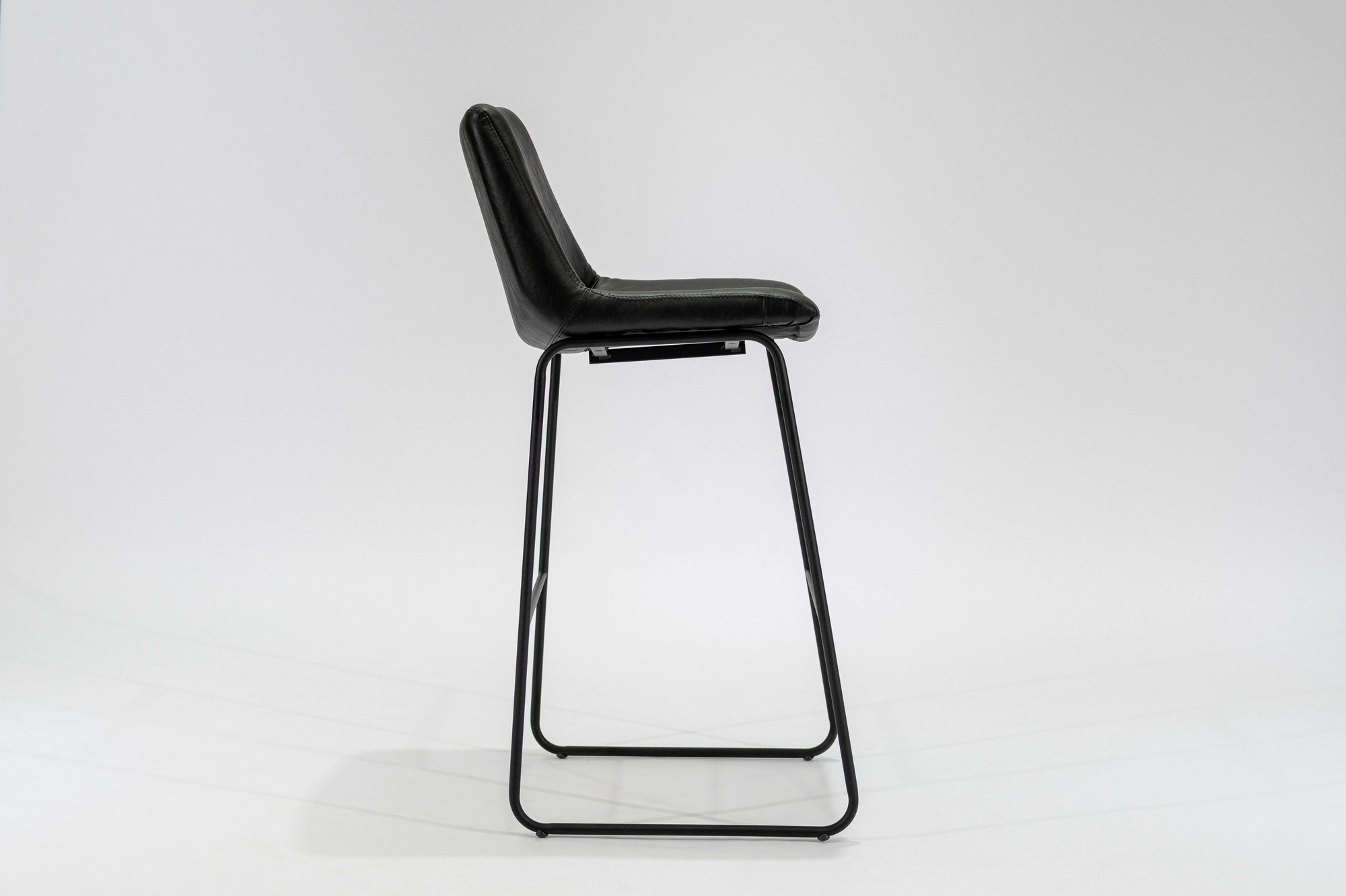 banqueta-simil-cuero-negro-hierro-negro-lateral Banqueta tapizada en simil cuero color negro con estructura de hierro negro microtexturado vista lateral