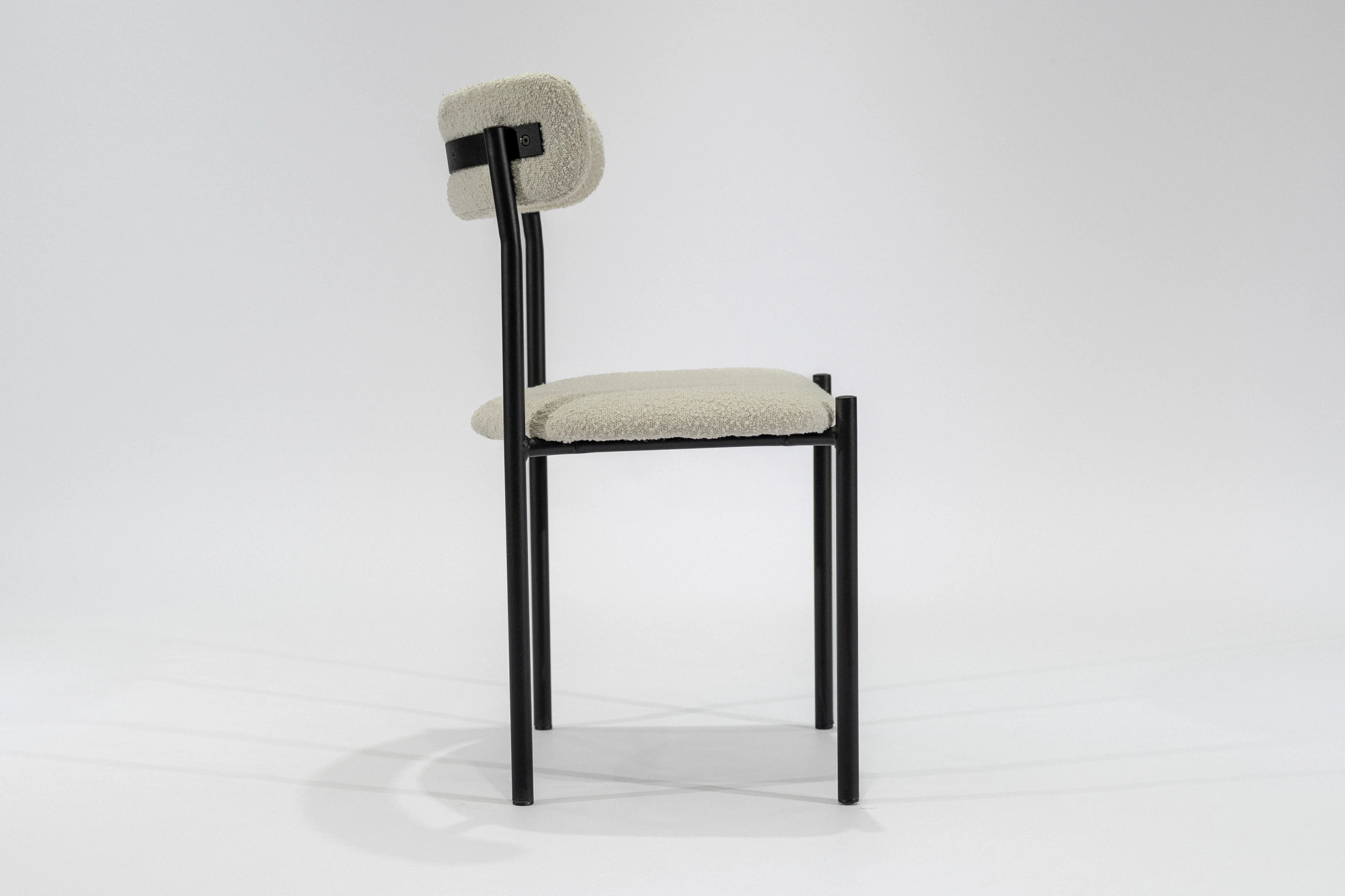 silla-comedor-tapizada-boucle-blanco-hierro-negro-lateral Silla de comedor tapizada en boulcé color blanco con estructura de hierro negro microtexturado vista lateral