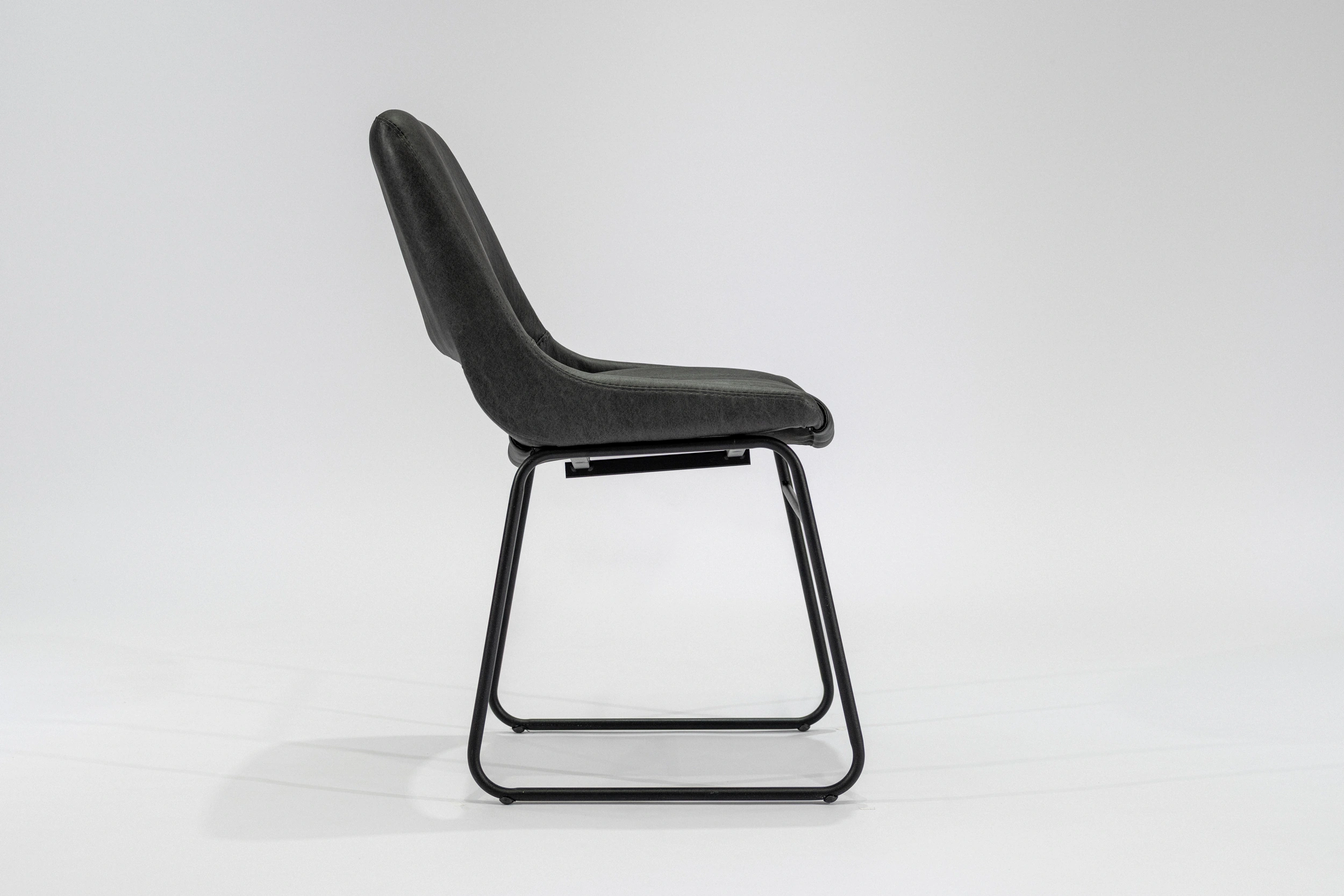 silla-comedor-tapizada-simil-cuero-gris-oscuro-hierro-negro-lateral Silla de comedor tapizada en ecocuero color gris oscuro con estructura de hierro negro microtexturado vista lateral