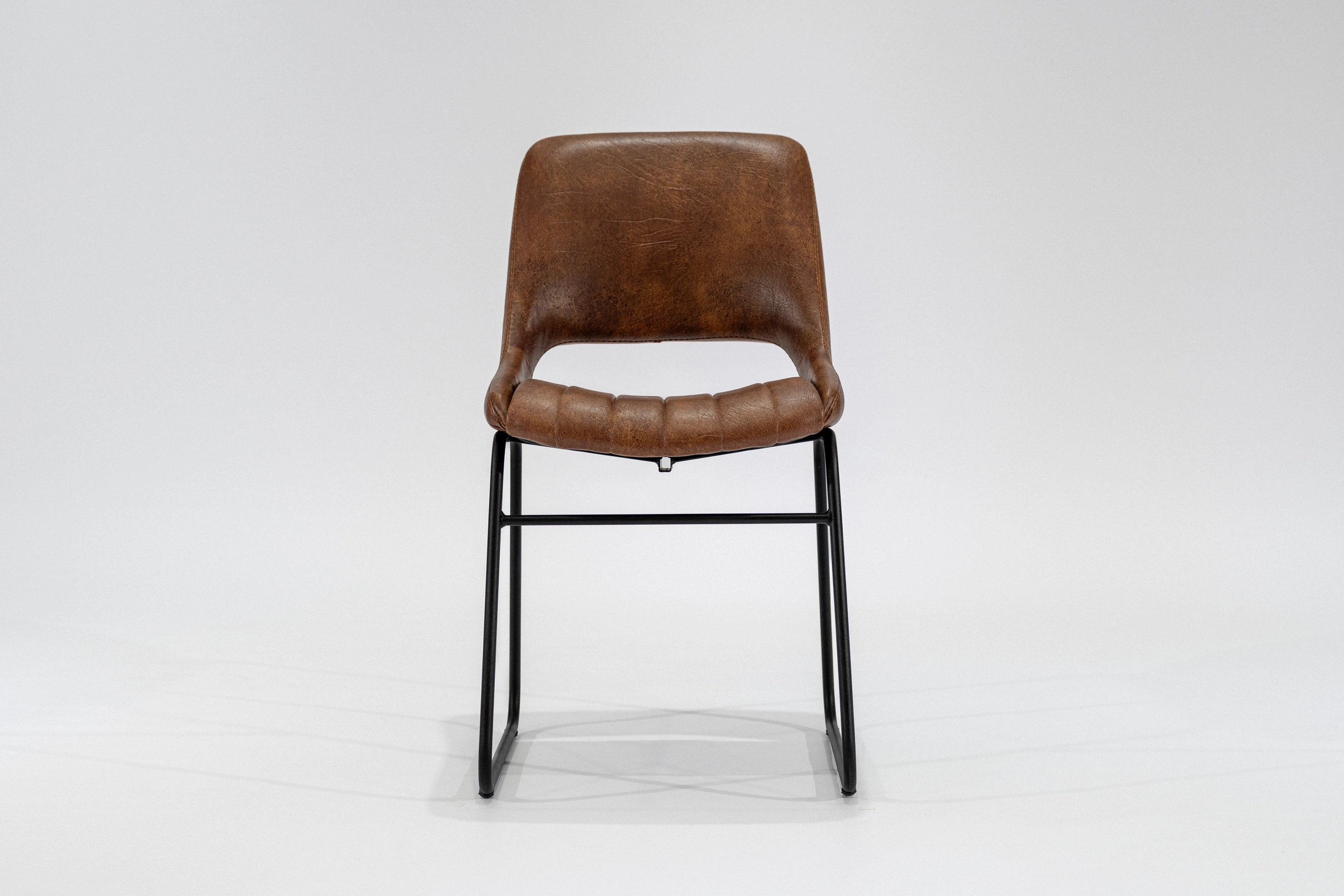 silla-comedor-tapizada-simil-cuero-habano-hierro-negro-frontal... Silla de comedor tapizada en ecocuero color habano con estructura de hierro negro microtexturado vista frontal