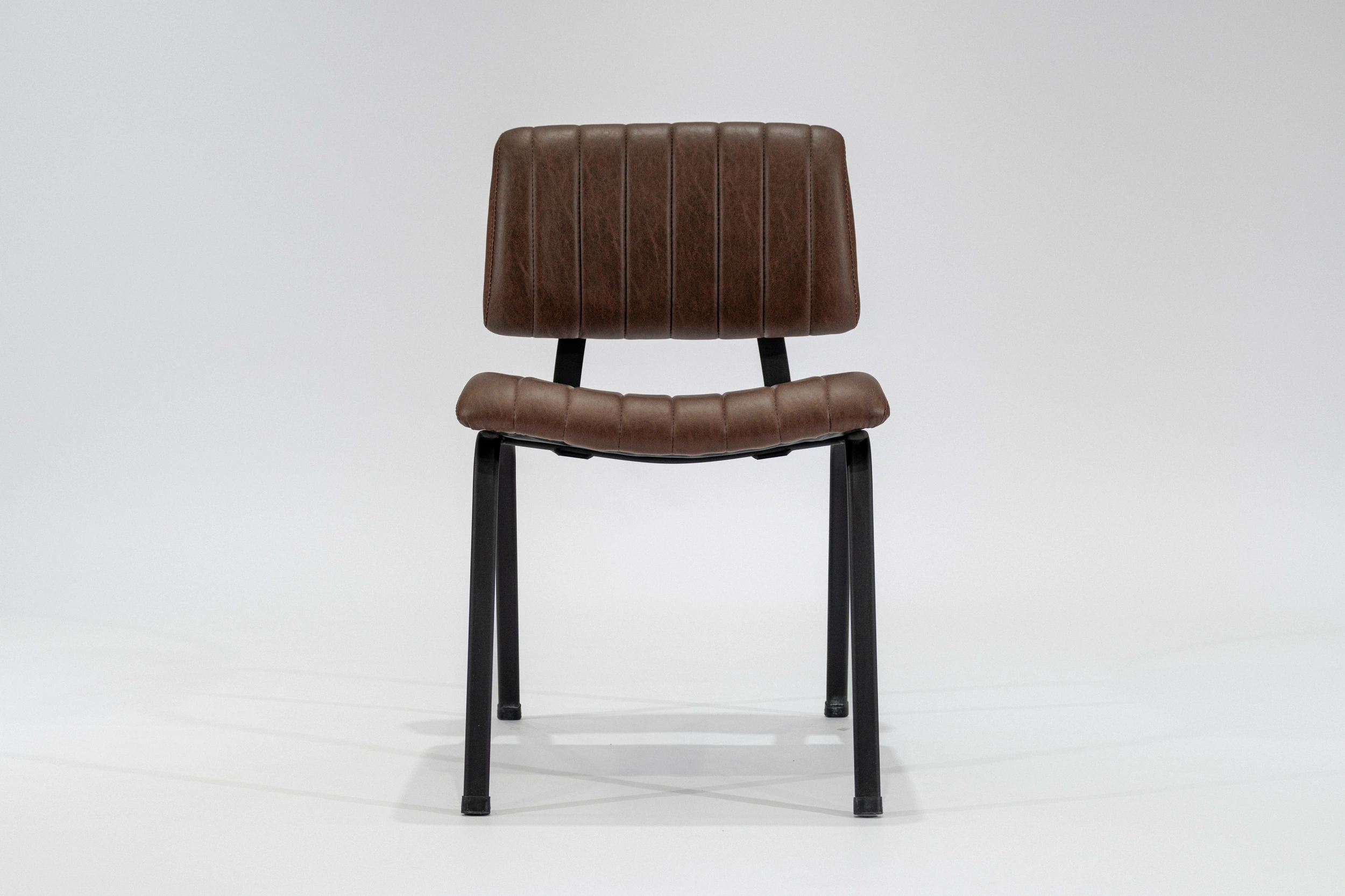 silla-comedor-tapizada-simil-cuero-habano-hierro-negro-frontal.. Silla de comedor tapizada en ecocuero color habano con estructura de hierro negro microtexturado vista frontal