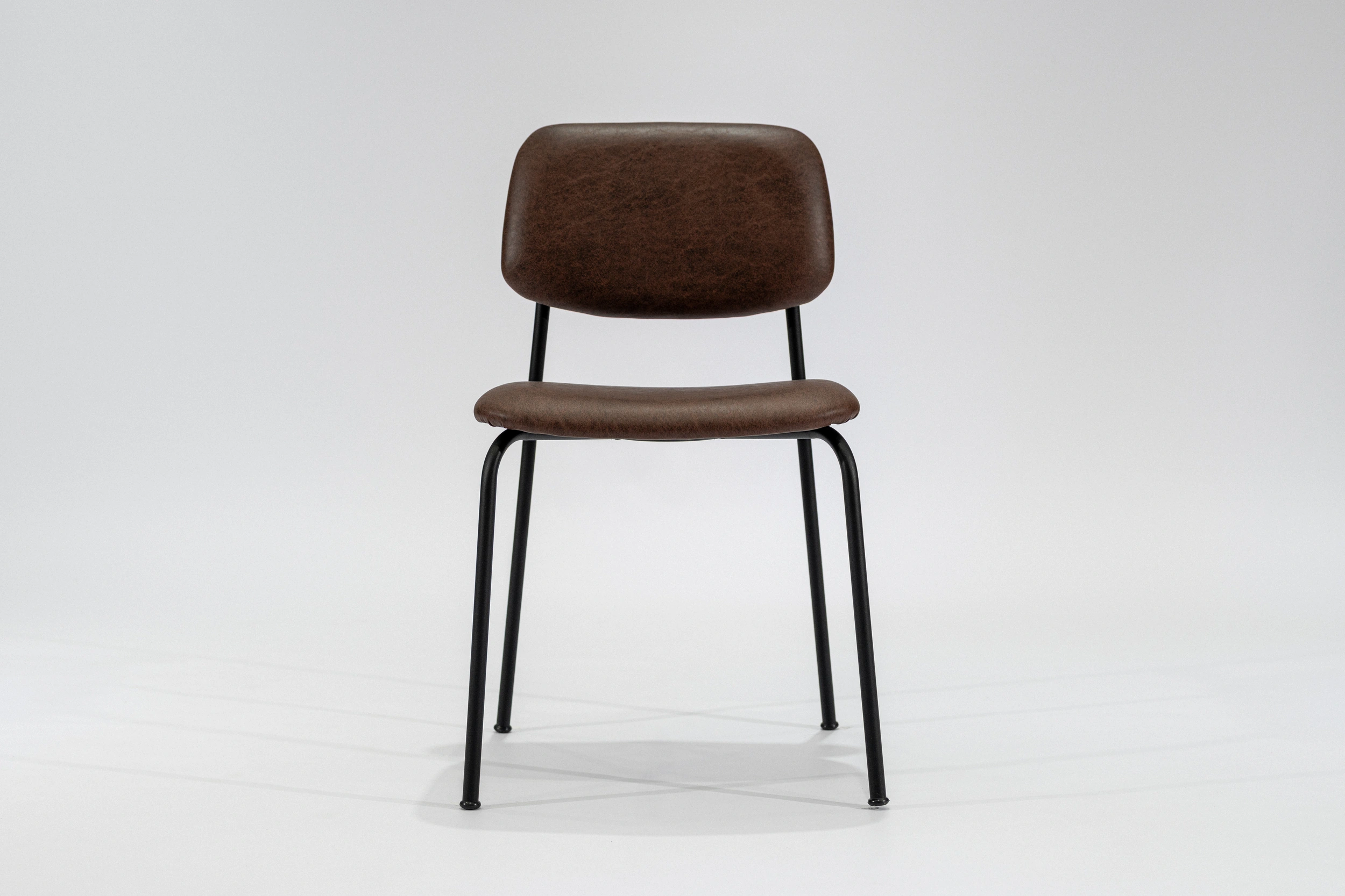silla-comedor-tapizada-simil-cuero-habano-hierro-negro-frontal. Silla de comedor tapizada en ecocuero color habano con estructura de hierro negro microtexturado vista frontal.