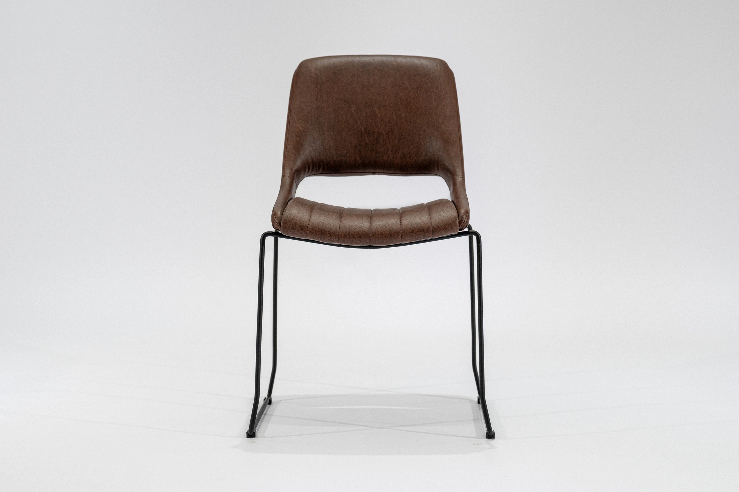 silla-comedor-tapizada-simil-cuero-habano-hierro-negro-frontal.... Silla de comedor tapizada en ecocuero color habano con estructura de hierro negro microtexturado vista frontal.
