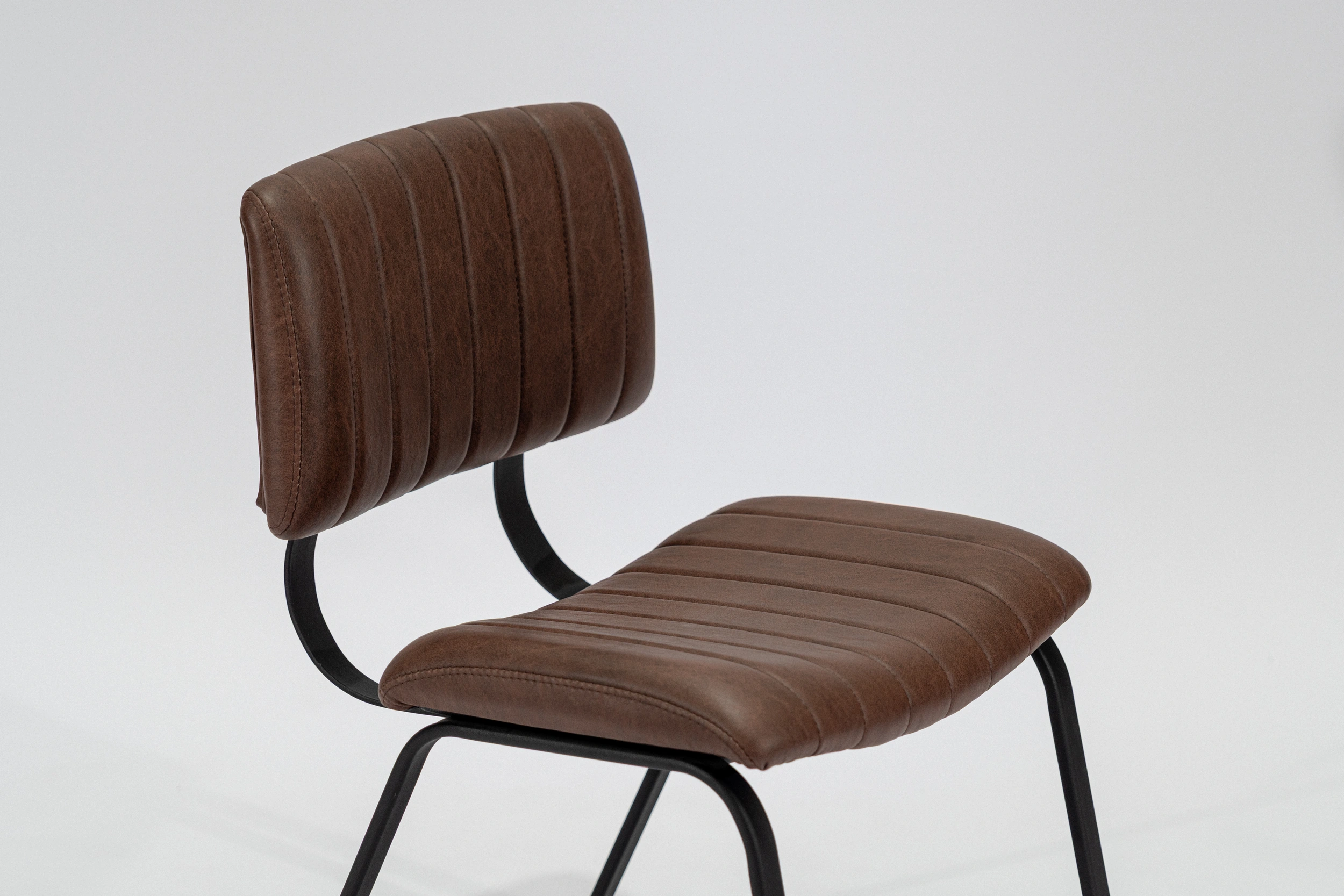silla-comedor-tapizada-simil-cuero-habano-hierro-negro-perspectiva.. Silla de comedor tapizada en ecocuero color habano con estructura de hierro negro microtexturado vista perspectiva