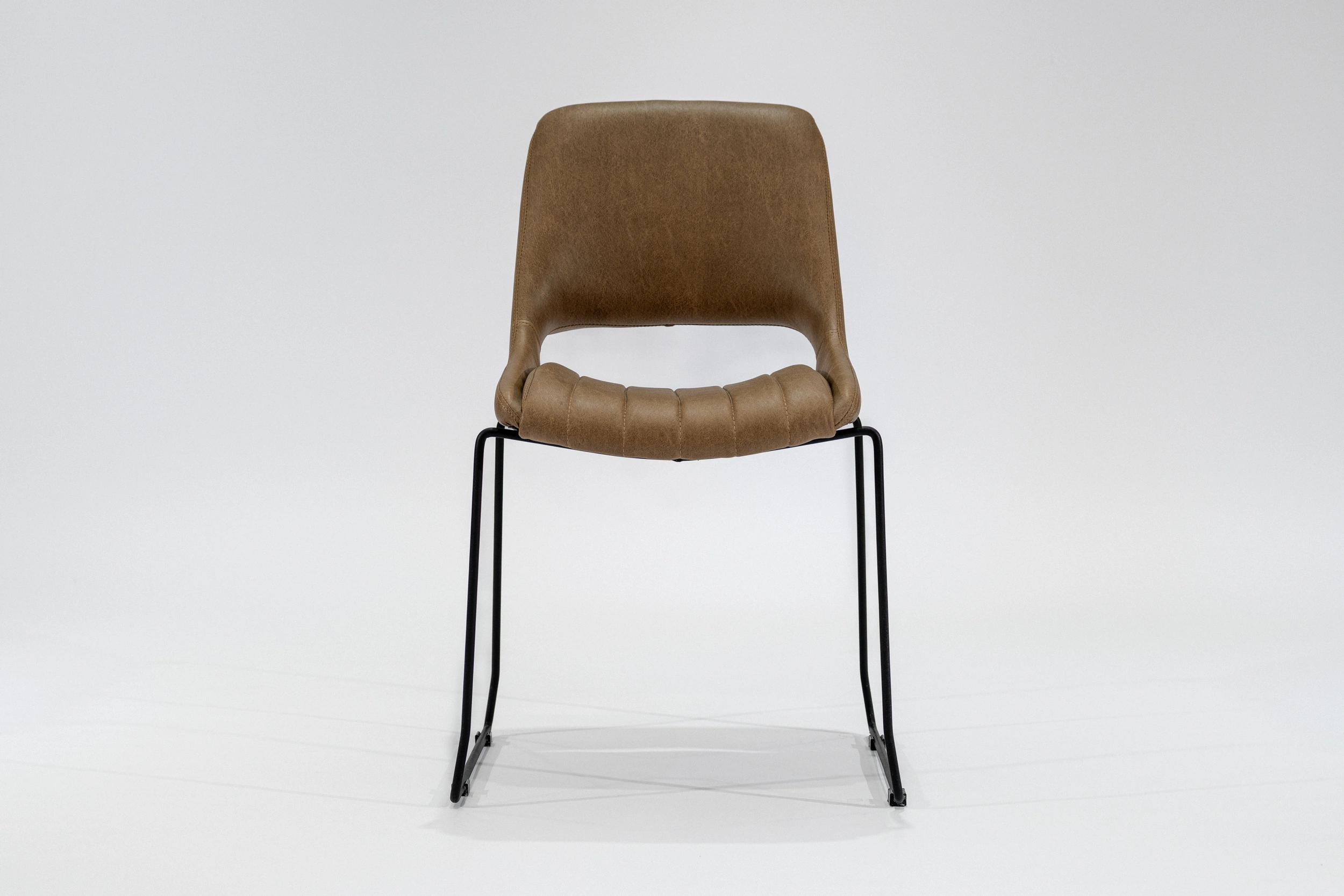 silla-comedor-tapizada-simil-cuero-marron-claro-hierro-negro-frontal Silla de comedor tapizada en ecocuero color marron claro con estructura de hierro negro microtexturado vista frontal.