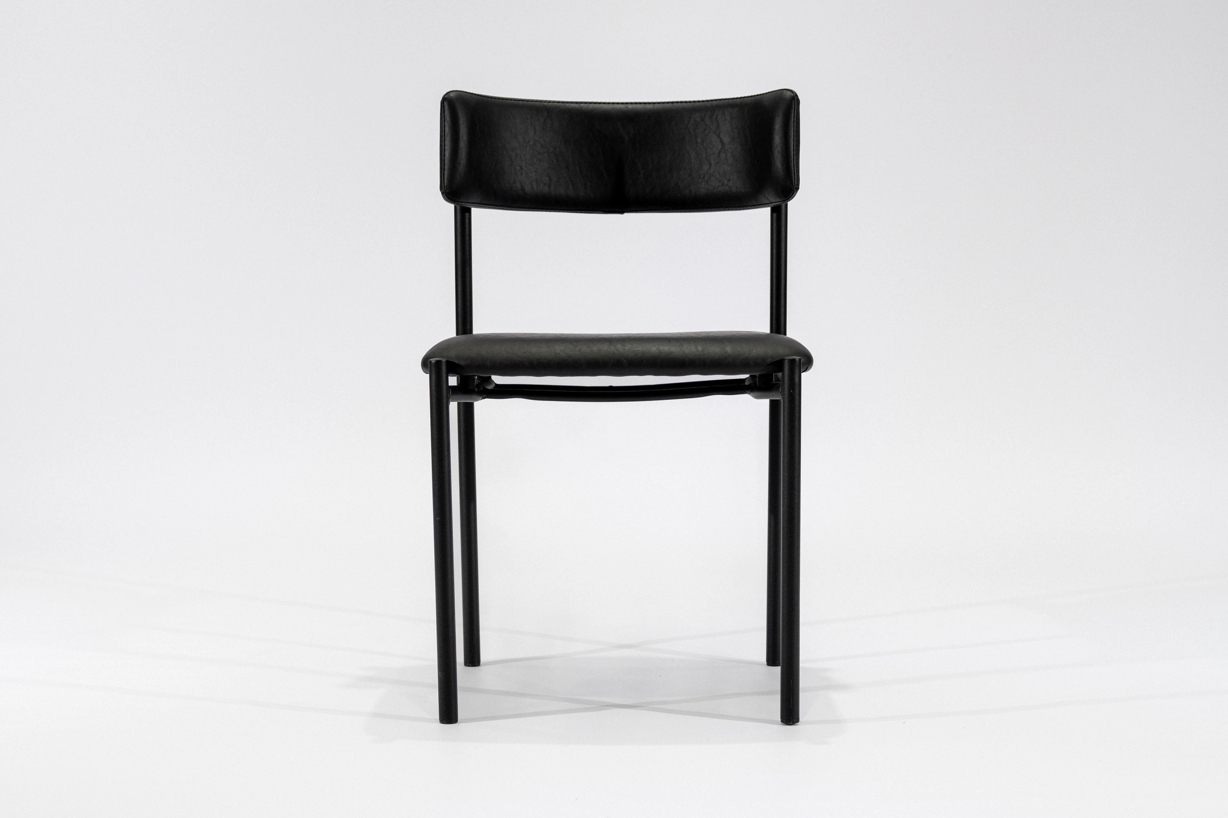 silla-comedor-tapizada-simil-cuero-negro-hierro-negro-frontal Silla de comedor tapizada en ecocuero color negro con estructura de hierro negro microtexturado vista frontal.