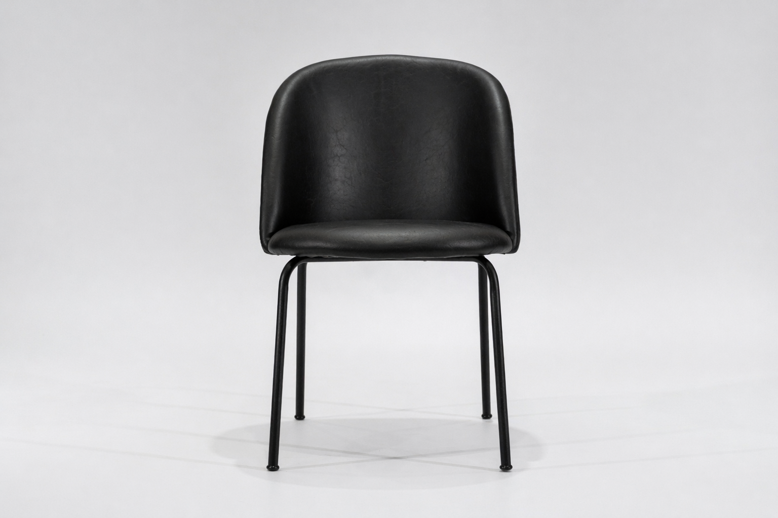 silla-comedor-tapizada-simil-cuero-negro-hierro-negro-frontal..... Silla de comedor tapizada en ecocuero color negro con estructura de hierro negro microtexturado vista frontal.