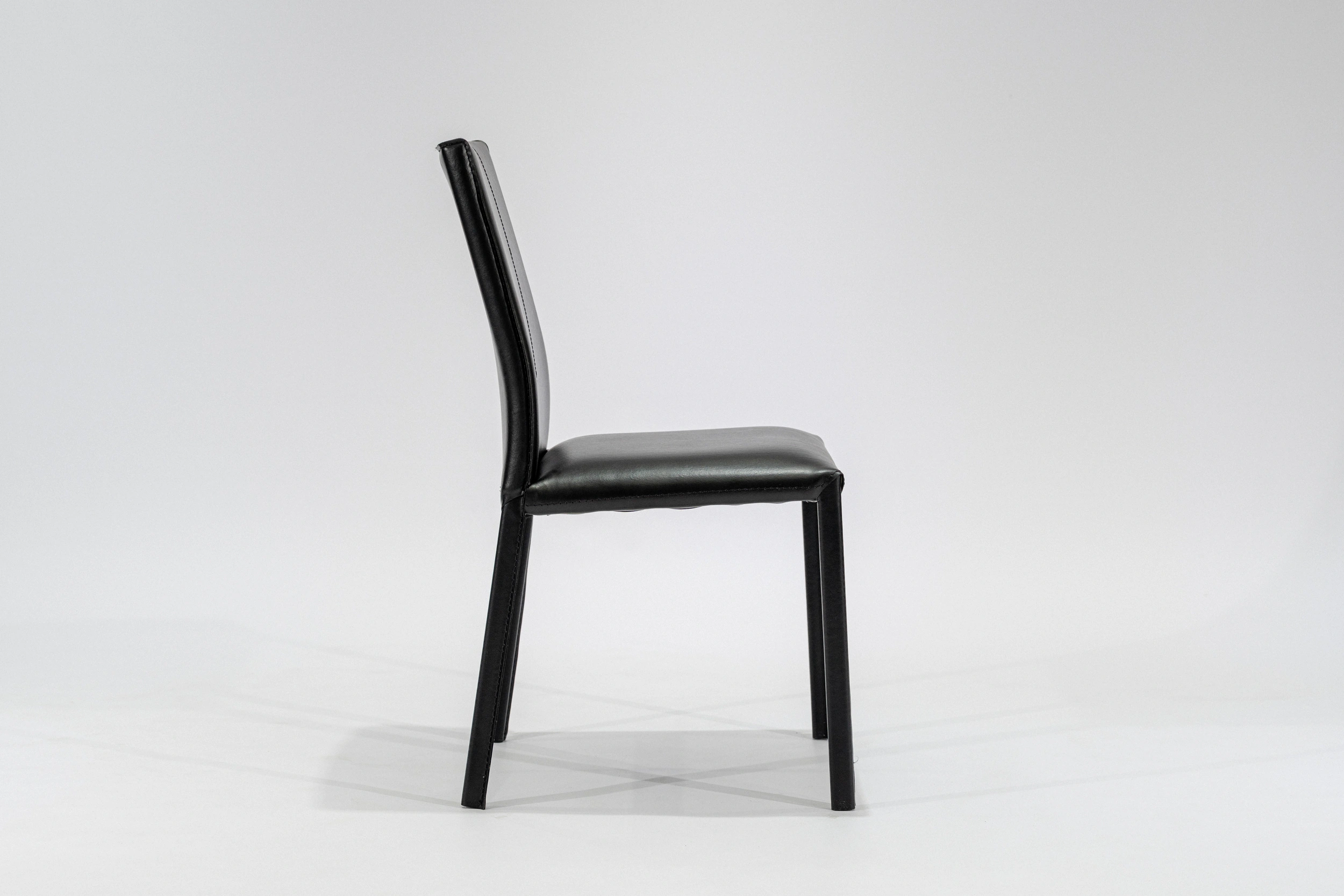 silla-comedor-tapizada-simil-cuero-negro-hierro-negro-lateral... Silla de comedor tapizada en ecocuero color negro con estructura de hierro negro microtexturado vista lateral