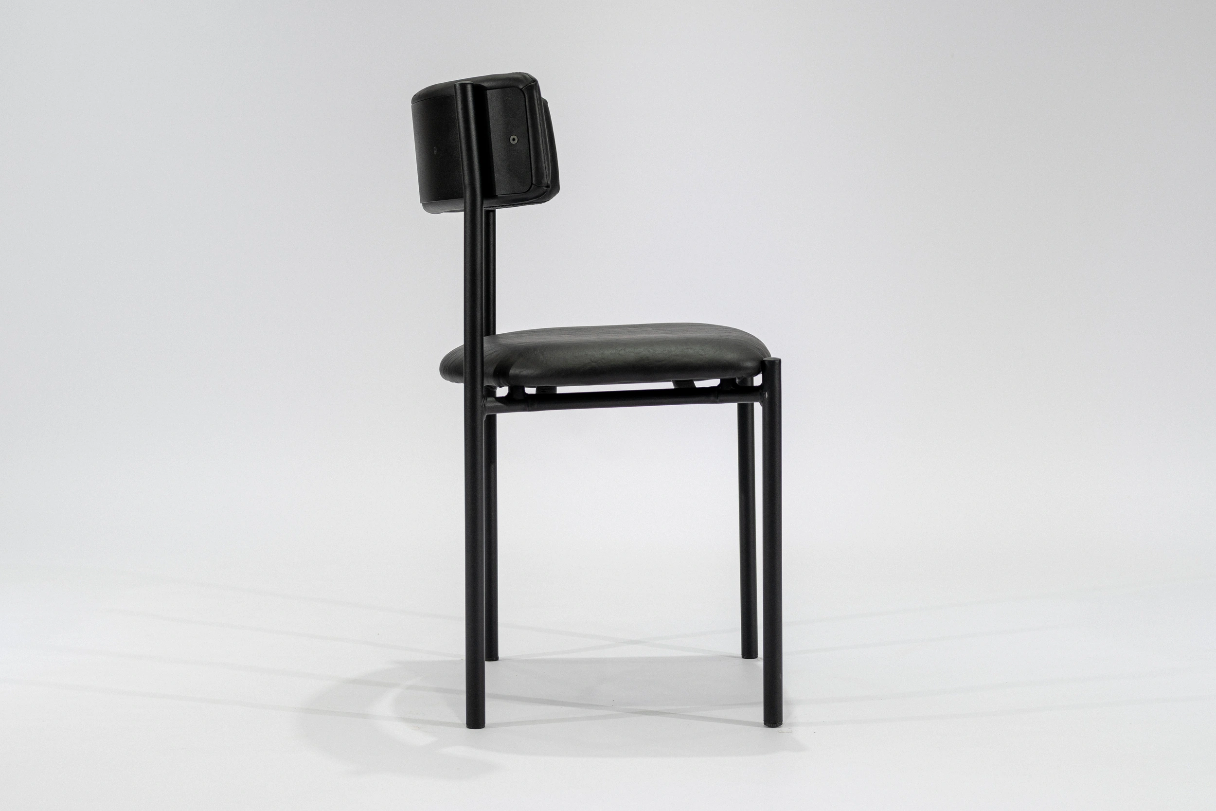 silla-comedor-tapizada-simil-cuero-negro-hierro-negro-lateral Silla de comedor tapizada en ecocuero color negro con estructura de hierro negro microtexturado vista lateral