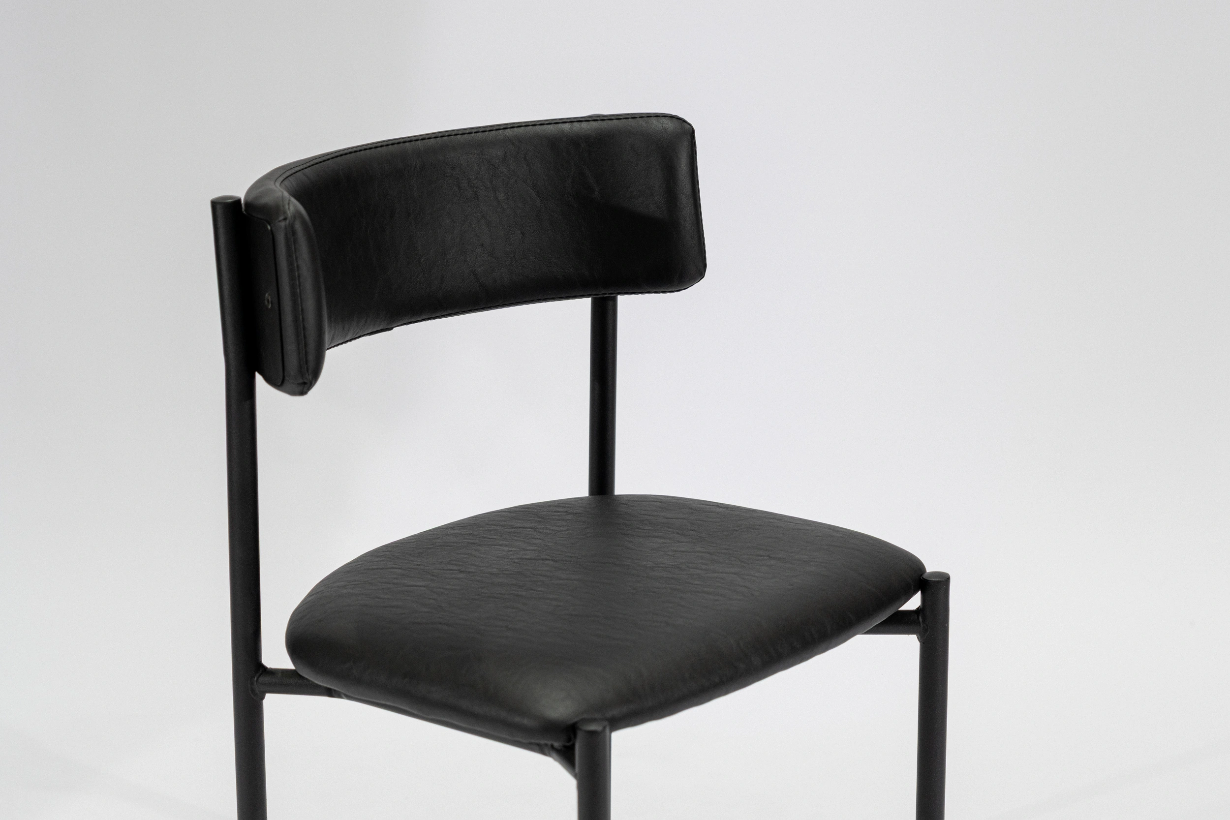 silla-comedor-tapizada-simil-cuero-negro-hierro-negro-perspectiva Silla de comedor tapizada en ecocuero color negro con estructura de hierro negro microtexturado vista perspectiva