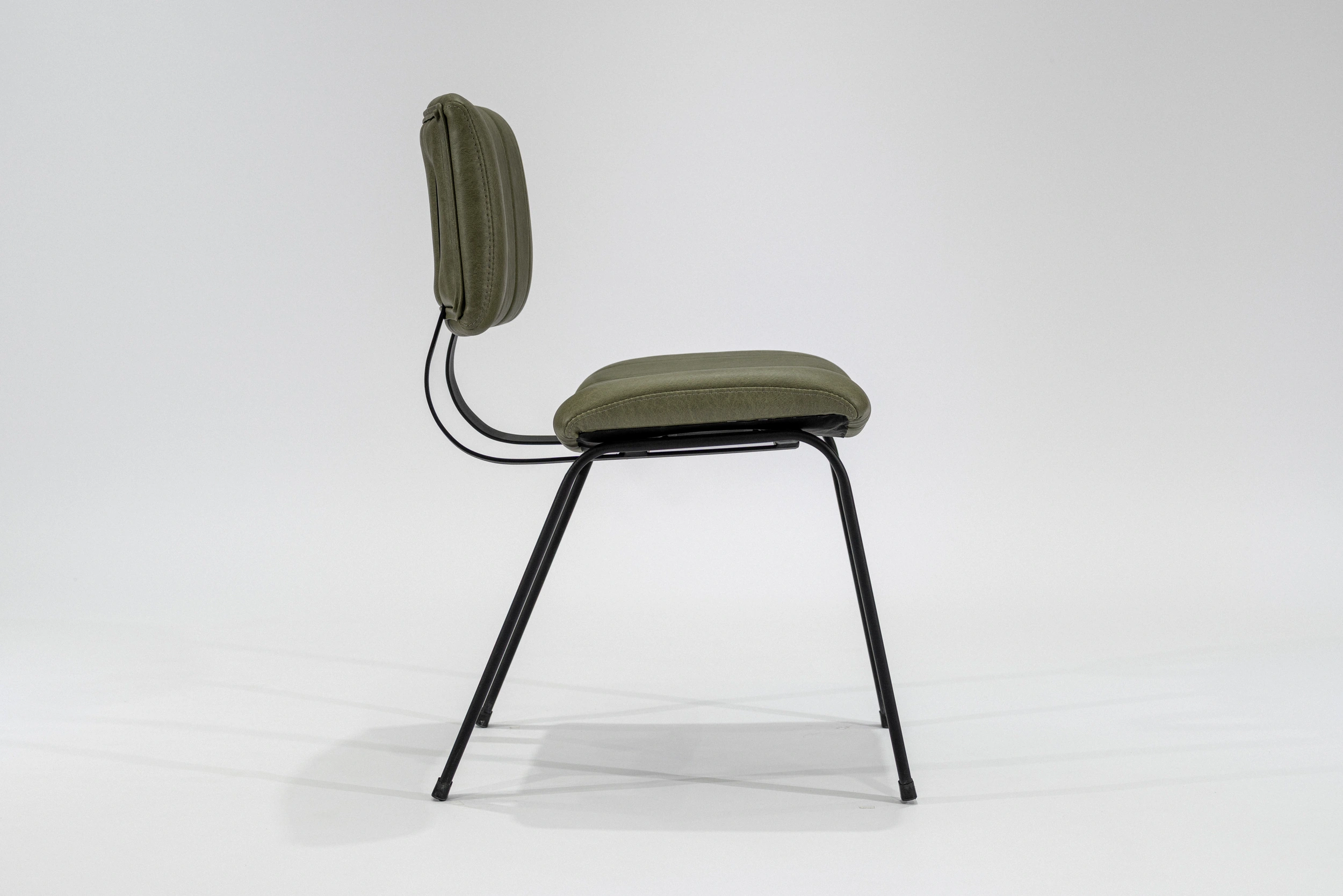 silla-comedor-tapizada-simil-cuero-verde-seco-hierro-negro-lateral Silla de comedor tapizada en ecocuero color verde seco con estructura de hierro negro microtexturado vista lateral
