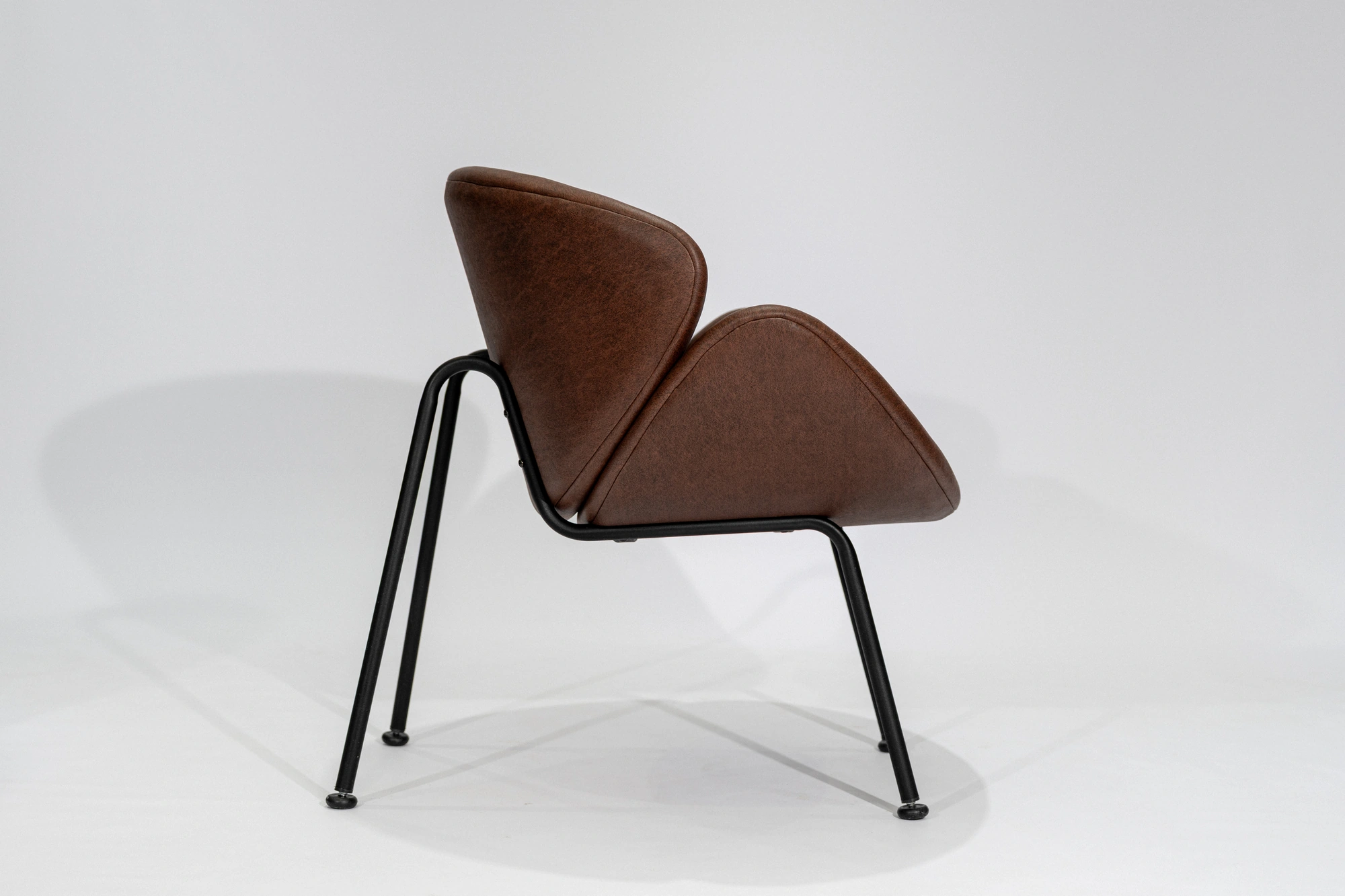 silla-poltrona-simil-cuero-habano-hierro-negro-lateral Silla poltrona tapizada en tela simil cuero color marrón habano con estructura de hierro negro microtexturado vista lateral