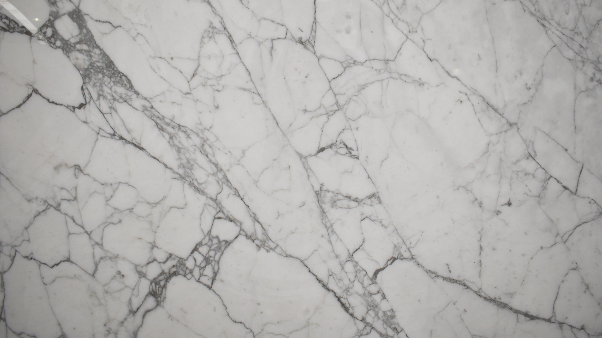 marmol-calacatta Placa de mármol Calacatta natural con fondo blanco y amplias vetas grises, ideal para revestimientos, baños y proyectos de interiorismo.