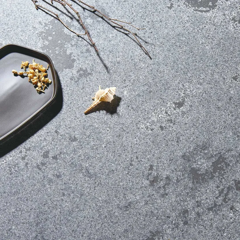 purastone-pura-concrete-dark-detalle-superficie Purastone Pura Concrete Dark de cuarzo en tono gris oscuro con matices y marcas inspiradas en el hormigón, ideal para mesadas, islas, mesas y revestimientos interiores.